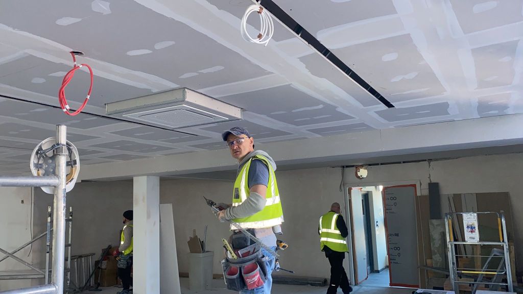 Construction team working on plasterboard ceilings during an OSREND drylining project