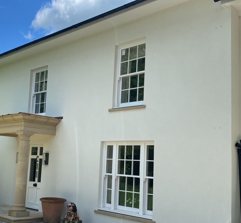 Finished exterior rendered wall with windows and decorative stone detailing.