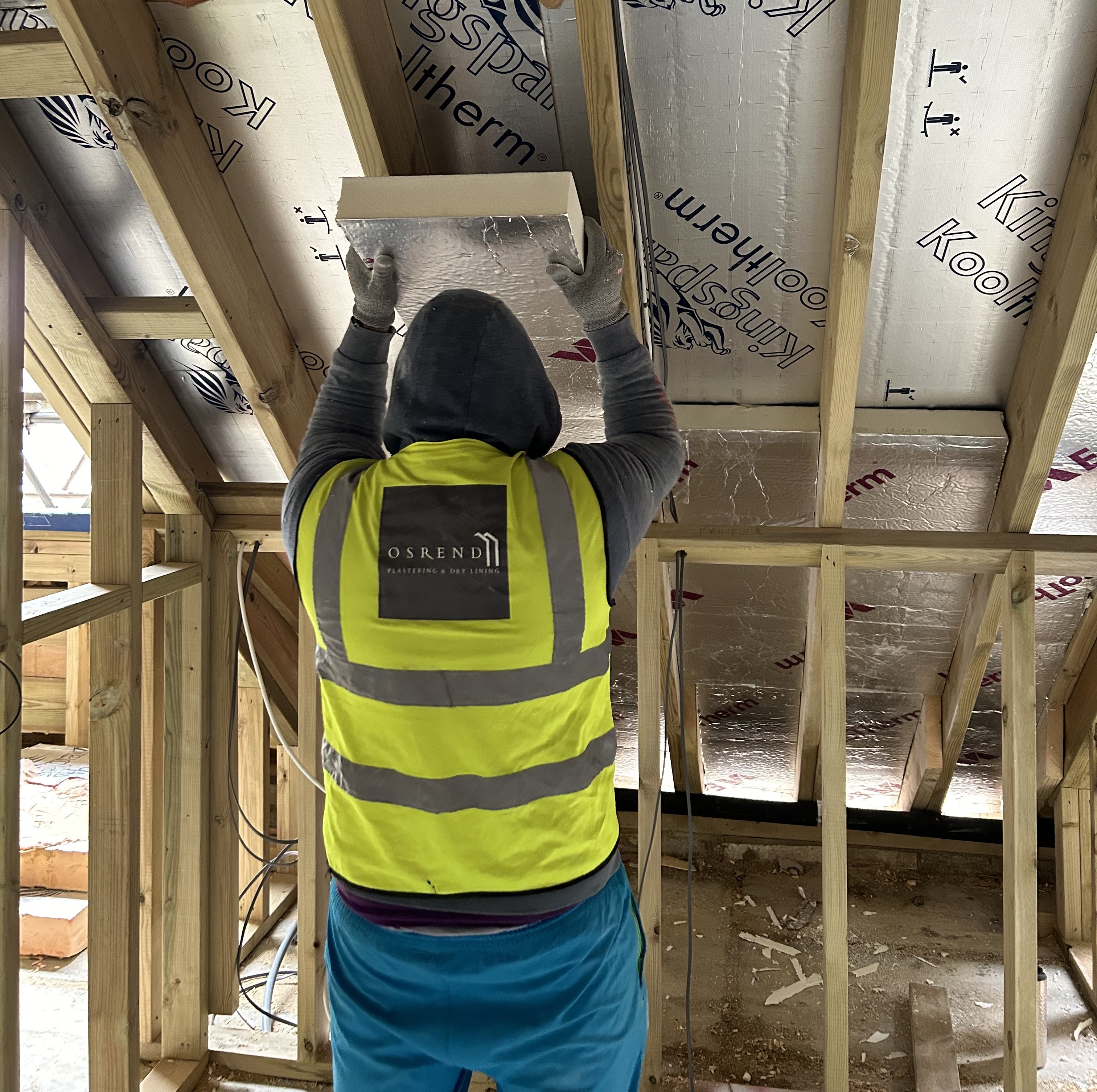 OSREND worker installing insulation between timber roof rafters